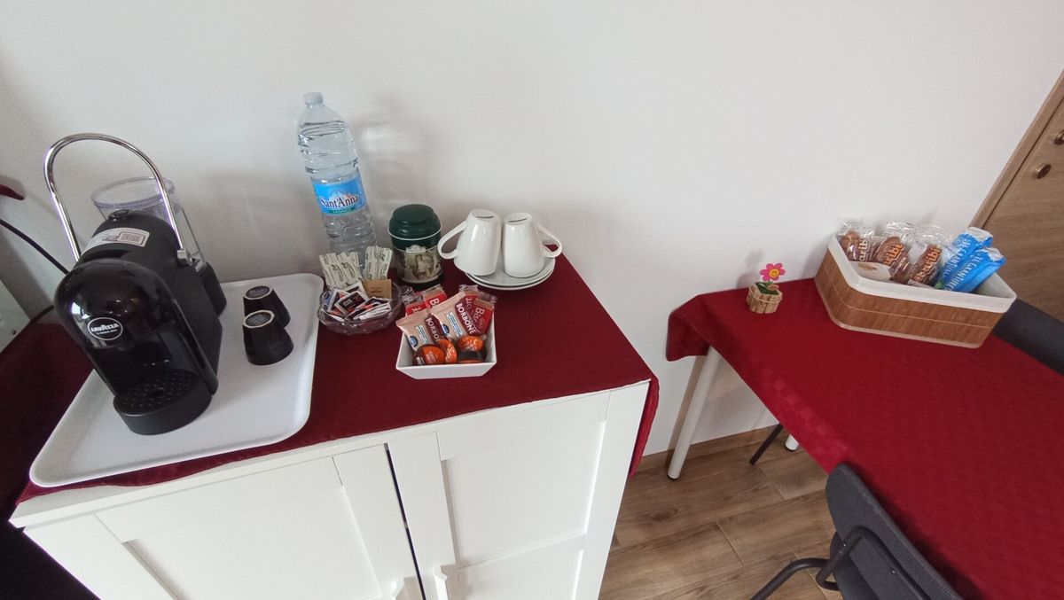 Angolo caffè con macchina, bollitore e cestino di benvenuto