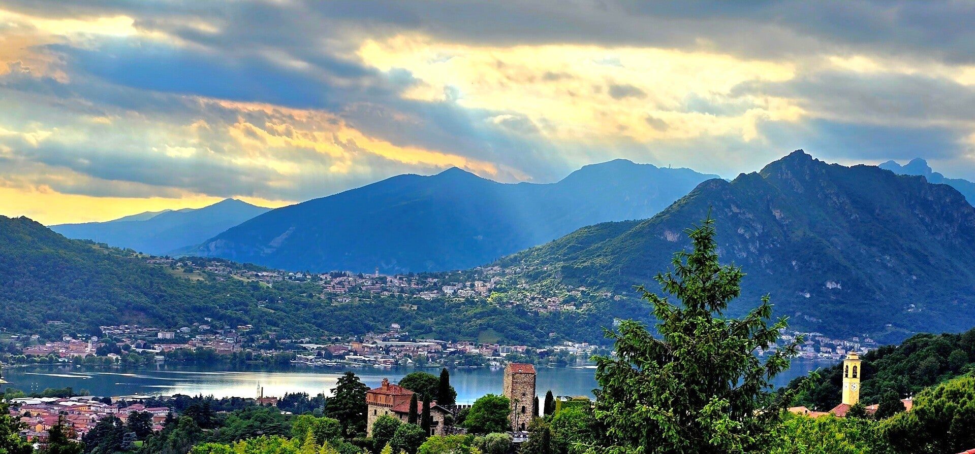 Vista dalla Dimora dei Due Laghi al tramonto: il lago, il Castello di Rossino e le montagne